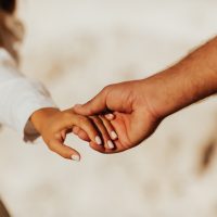 Lovely couple holding hands on white background. Couple together outdoors in love and romantic relationship. Close-up of hands.